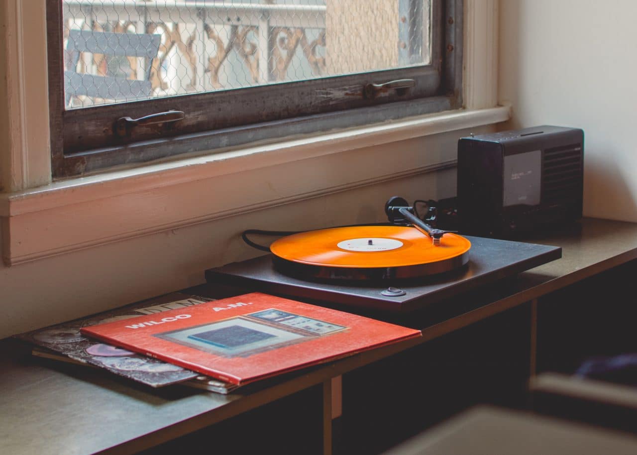 Can You Listen to Music with Hearing Aids? Vinyl records and record player near a window